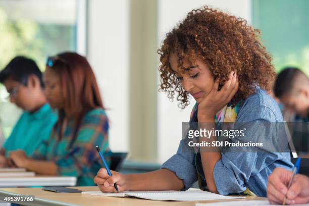 high school or college girl taking exam in classroom - cute college girl stockfoto's en -beelden