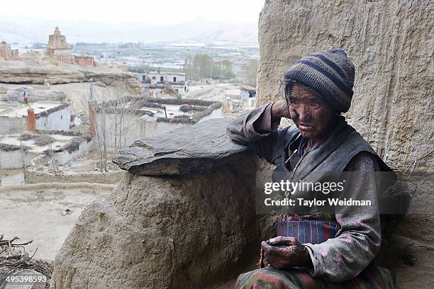 Pema Dolma sits in front of her cliffside home on May 24, 2014 in Chosher, Nepal. Humans have lived in caves carved out of the Mustang cliffsides for...