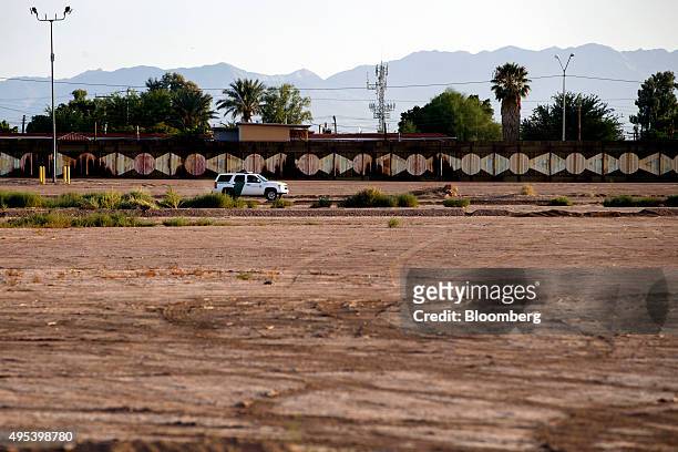 Border Patrol sports utility vehicle drives along the border fence in Calexico, California, U.S., on Monday, Oct. 12, 2015. Among Rabobank's 119...