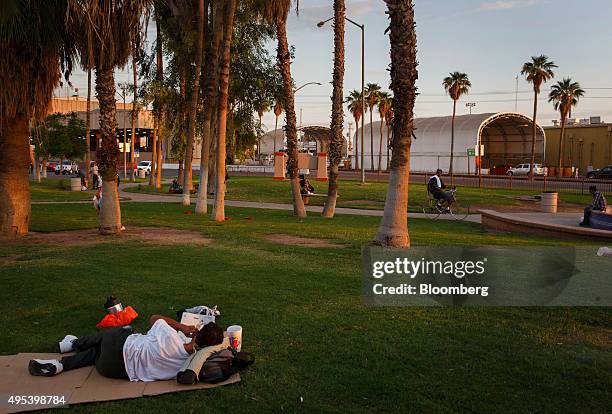 Man lies on cardboard at the Border Friendship Park adjacent to the U.S. Border Inspection Station in Calexico, California, U.S., on Monday, Oct. 12,...