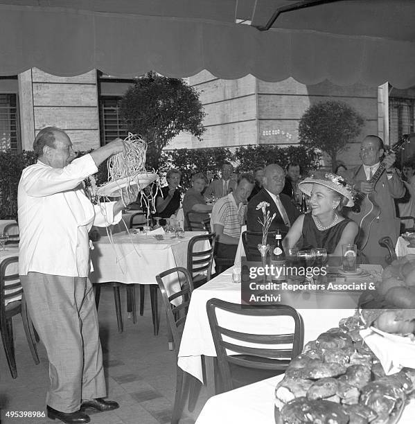 British-born American actress Jean Fontaine smiling while looking at the Alfredo's restaurant well-known fettuccine. Rome, 1956