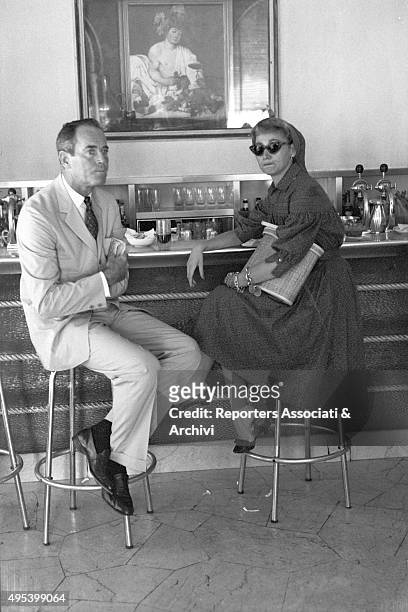American actor Henry Fonda and his wife Afdera Franchetti sitting at the counter of the Doney bar on via Veneto. Rome, 1st August 1959