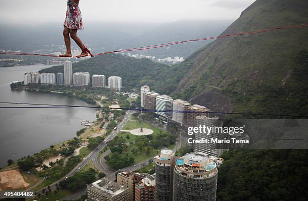 Participant balances on a slackline set up between rocks in the Cantagalo favela community during the Highgirls Brasil festival on November 2, 2015...