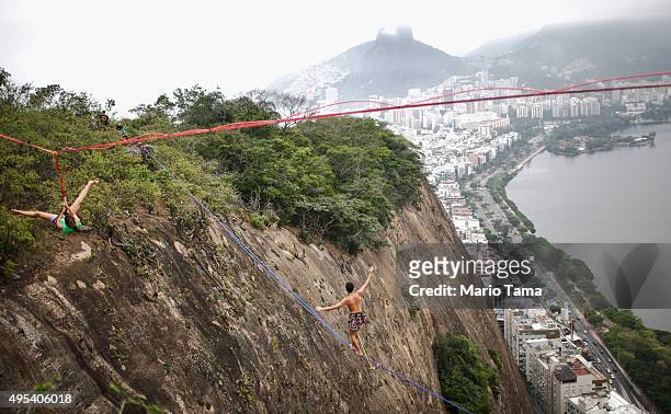 Participants balance on slacklines set up between rocks in the Cantagalo favela community during the Highgirls Brasil festival on November 2, 2015 in...