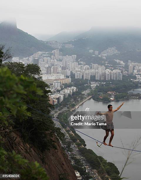 Participant balances on a slackline set up between rocks in the Cantagalo favela community during the Highgirls Brasil festival on November 2, 2015...