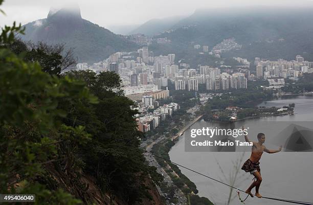 Participant balances on a slackline set up between rocks in the Cantagalo favela community during the Highgirls Brasil festival on November 2, 2015...