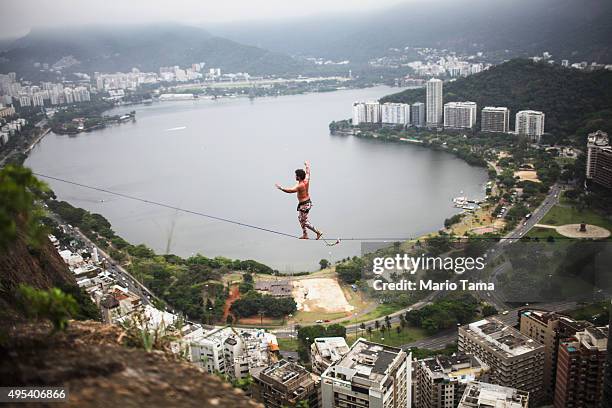 Participant balances on a slackline set up between rocks in the Cantagalo favela community during the Highgirls Brasil festival on November 2, 2015...