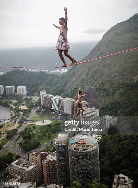 Participants balance on slacklines set up between rocks in the Cantagalo favela community during the Highgirls Brasil festival on November 2, 2015 in...