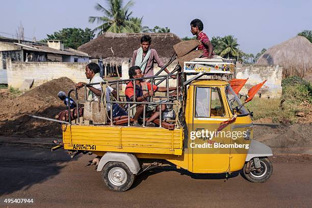 People ride on an auto-rickshaw past buildings on the proposed site of the Andhra Pradesh state capital "Amaravati" near Uddandarayunipalem, Andhra...