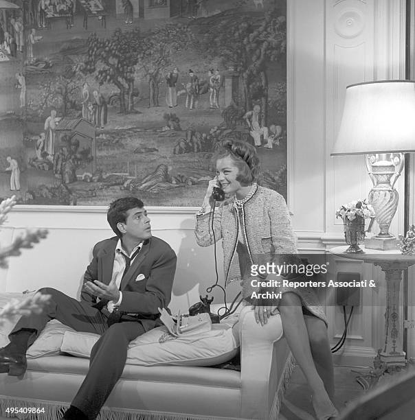 German-born French actress Romy Schneider phone calling beside Cuban-born American actor Tomas Milian in the episode Il lavoro from the film...