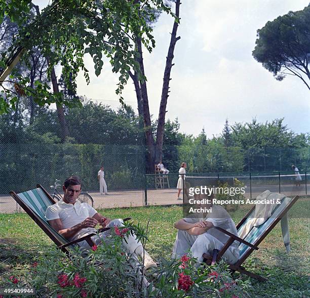 Italian actor Fabio Testi and Austrian actor Helmut Berger sitting on two beach chairs in a scene from the film The Garden of the Finzi-Continis....