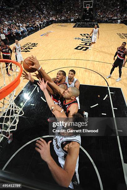 LaMarcus Aldridge and Nicolas Batum of the Portland Trail Blazers rebound the ball against Tim Duncan and Marco Belinelli of the San Antonio Spurs in...