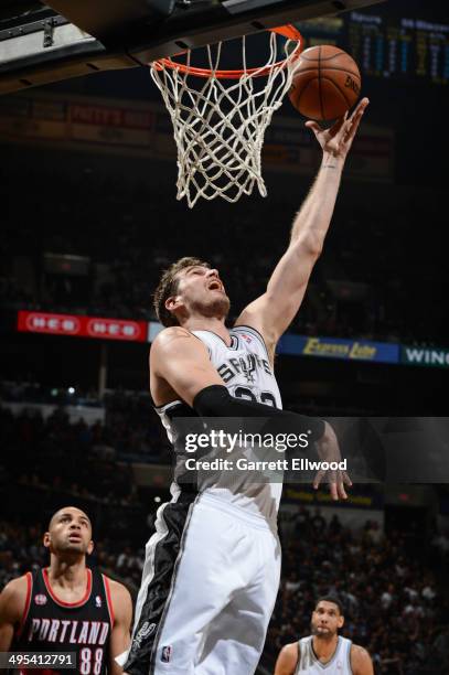Tiago Splitter of the San Antonio Spurs lays the ball in the basket against Nicolas Batum of the Portland Trail Blazers in Game Two of the Western...