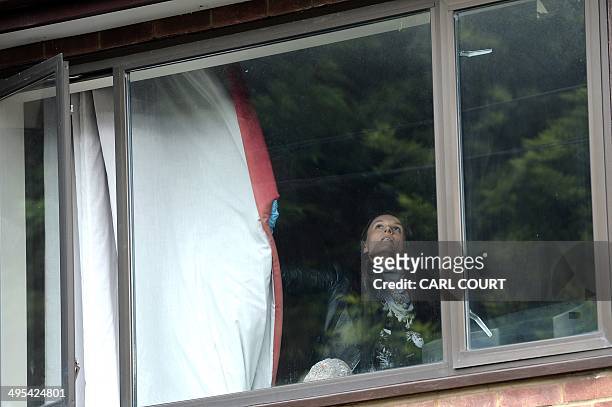 Police officer closes a curtain as she searches the house of Altaf Hussain, the leader of Pakistan's Muttahida Qaumi Movement party, in northwest...