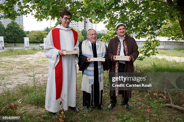 Rabbi Tovia Ben-Chorin , Father Gregor Hohberg and Imam Kadir Sanci hold symbolic bricks in their hands while standing at the construction site of...