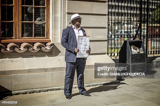 Supporter of Oscar Pistorius holds a placard as he stands in the courtyard of the appeal court in Bloemfontein on November 3, 2015. South African...