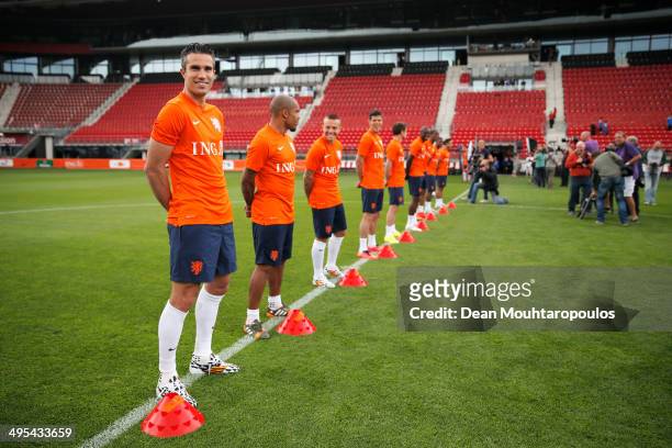 Robin Van Persie of the Netherlands smiles as he waits for photographers to take his portrait prior to the Netherlands training session held at the...