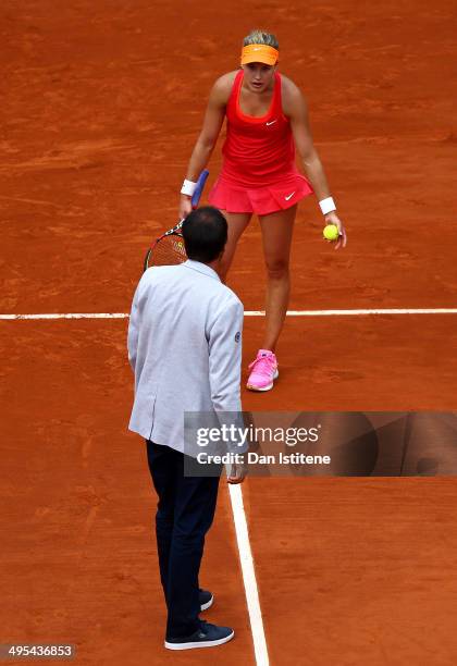 Eugenie Bouchard of Canada discusses a line call with the chair umpire during her women's singles quarter-final match against Carla Suarez Navarro of...