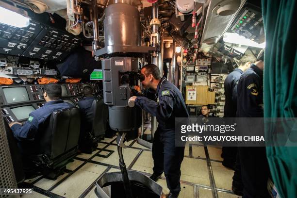 The submarine commander watches through the periscope of the BNS S34 Tikuna Brazilian diesel-electric powered type 209 attack submarine during a...