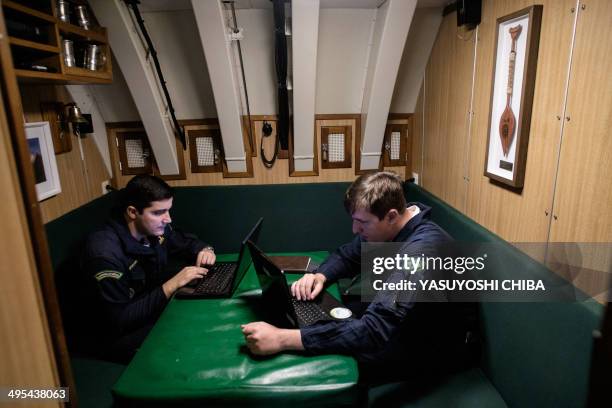 Two officers work on their noteboks in the BNS S34 Tikuna Brazilian diesel-electric powered type 209 attack submarine during a drill while moored at...