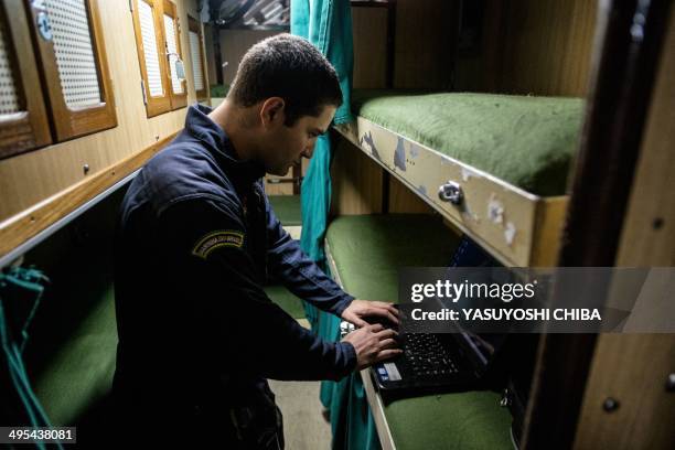 Crew member works with his notebook on his bunk inside the BNS S34 Tikuna Brazilian diesel-electric powered type 209 attack submarine during a drill...