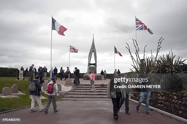 People visit a D-Day commemoration plaque and sculpture in hommage to Kieffer Commando near the beach in Ouistreham, northwestern France, on June 3...
