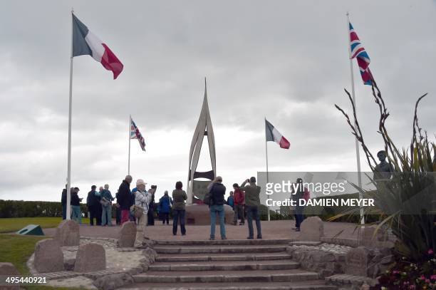 People visit a D-Day commemoration plaque and sculpture in hommage to Kieffer Commando near the beach in Ouistreham, northwestern France, on June 3...