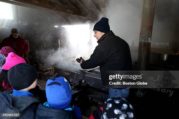 William Comery with a group of students from the Sam Placentino Elementary School from Holliston inside the sugaring shack at the Moose Hill Wildlife...
