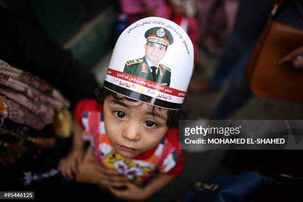 An Egyptian child with a portrait of ex-army chief Abdel Fattah al-Sisi on his head takes part in celebrations in Cairo's Tahrir Square on June 3,...