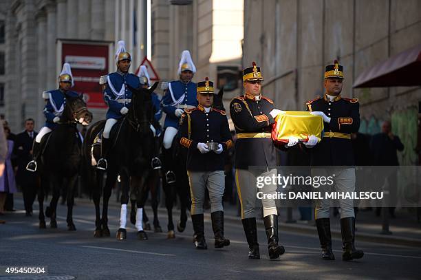 Romanian guard soldiers carry the gilded silver casket containing the heart of the Queen Marie of Romania covered by a national flag on their way to...