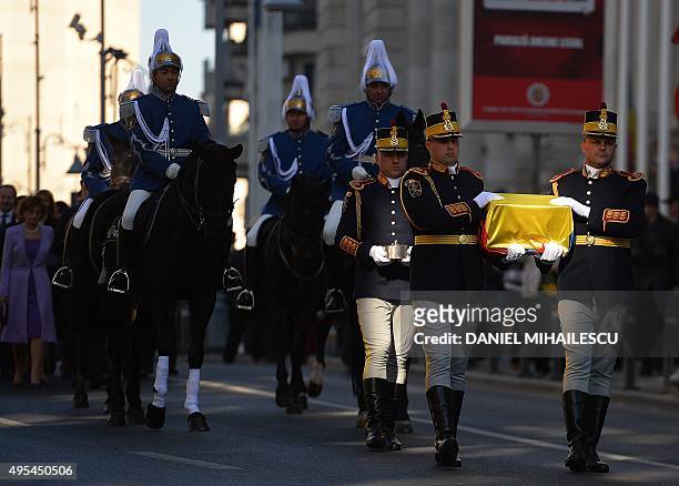 Romanian guard soldiers carry the gilded silver casket containing the heart of the Queen Marie of Romania covered by a national flag on their way to...