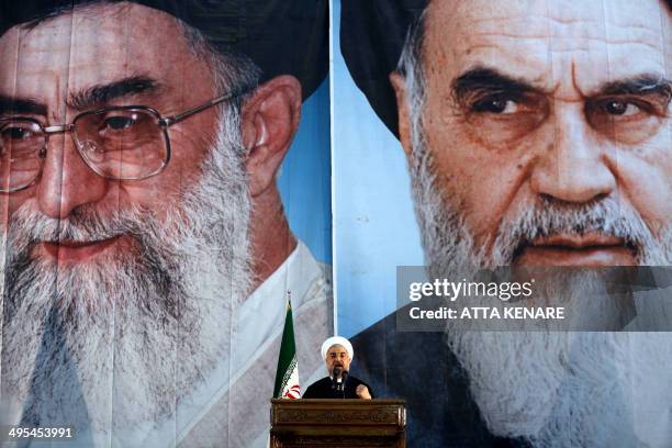 Iranian President Hassan Rouhani delivers a speech under portraits of Iran's supreme leader, Ayatollah Ali Khamenei and Iran's founder of the Islamic...