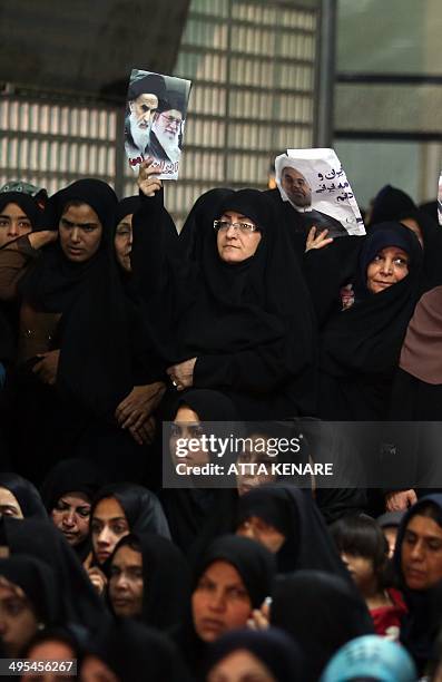 Iranian women hold photos of late Ayatollah Ruhollah Khomeini, Iran's supreme leader Ayatollah Ali Khamenei and Iran's President Hassan Rouhani,...