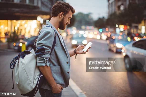 young man on the streets of big city. - taxi stock pictures, royalty-free photos & images
