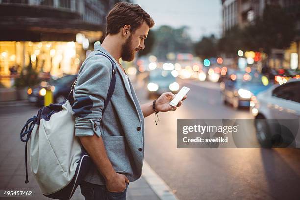 young man on the streets of big city. - mobile app car stock pictures, royalty-free photos & images