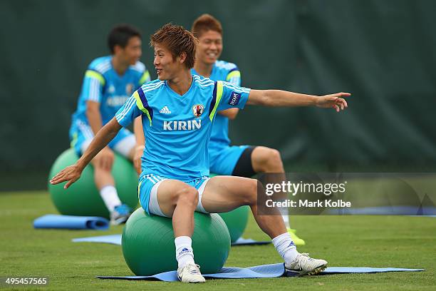 Yoichiro Kakitani stretches as he sits on a ball during a Japan training session at North Greenwood Recreation & Aquatic Complex on June 3, 2014 in...