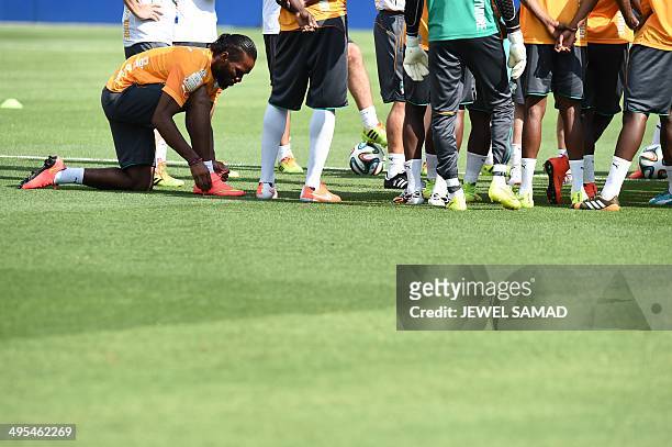Ivory Coast's forward Didier Drogba ties up his shoes during a training session at the Toyota Stadium in Frisco, Texas, on June 3 on the eve of their...