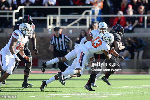 DeAndre Washington of the Texas Tech Red Raiders is tackled by Jordan Sterns of the Oklahoma State Cowboys during the game on October 31, 2015 at...