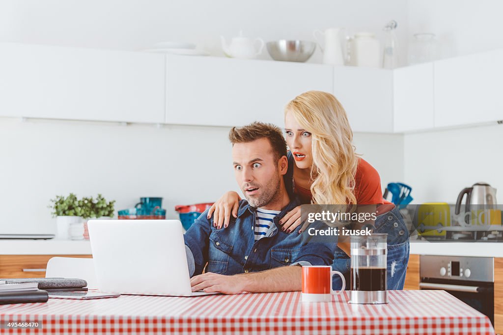 Überrascht Paar mit laptop in einem regionalen Küche