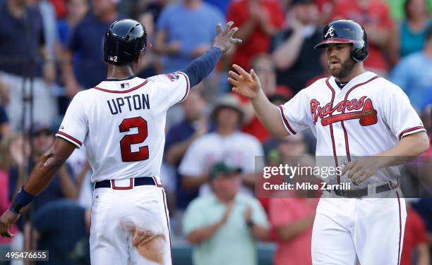 Catcher Evan Gattis of the Atlanta Braves is congratulated by centerfielder B.J. Upton after Gattis' home run in the first inning of the game against...