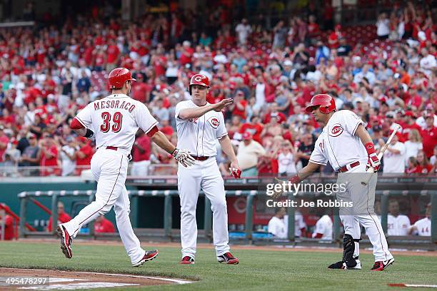 Devin Mesoraco of the Cincinnati Reds celebrates with teammates Jay Bruce and Brayan Pena after hitting a two-run home run in the first inning of the...