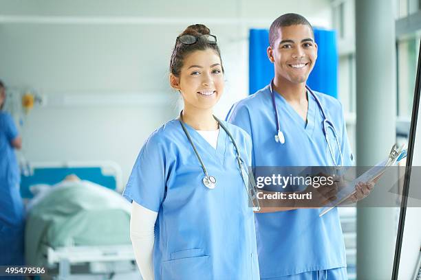 dos jóvenes enfermeras en la población - medical scrubs fotografías e imágenes de stock