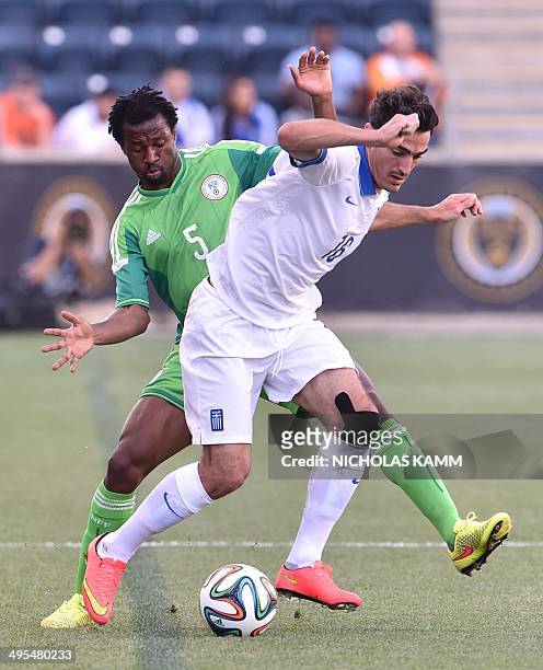 Efe Ambrose of Nigeria and Lazaros Christodouploulos of Greece vie for the ball during a World Cup preparation friendly match in Chester,...