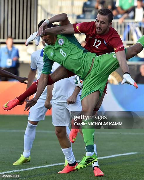 Peter Odemwingie of Nigeria collides with Panagiotis Glykos of Greece during a World Cup preparation friendly match in Chester, Pennsylvania, on June...