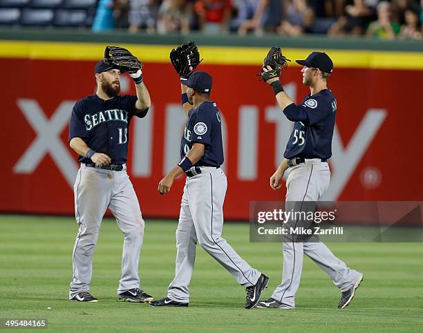 Outfielders Dustin Ackley, Endy Chavez and Michael Saunders of the Seattle Mariners celebrate after the game against the Atlanta Braves at Turner...