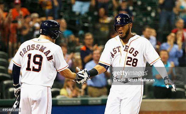 Jon Singleton of the Houston Astros is greeted behind the plate by Robbie Grossman after Singleton hit a solo home run in the eighth inning of their...