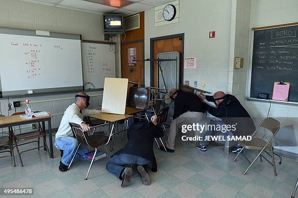 "Students" barricade a door of a classroom to block an "active shooter" during ALICE training at the Harry S. Truman High School in Levittown,...