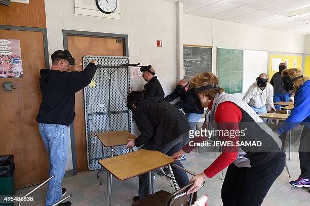 Participants barricade a door of a classroom to block an "active shooter" during ALICE training at the Harry S. Truman High School in Levittown,...