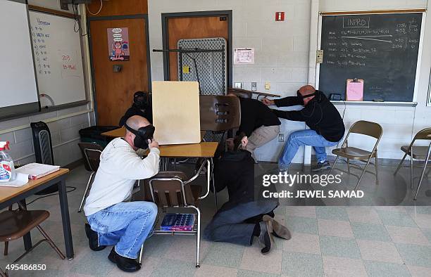 Participants barricade a door of a classroom to block an "active shooter" during ALICE training at the Harry S. Truman High School in Levittown,...