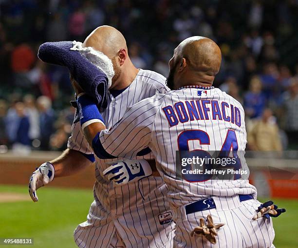 Nate Schierholtz of the Chicago Cubs gets a pie in the face by Emilio Bonifacio of the Chicago Cubs after Schierholtz' game-winning hit against the...